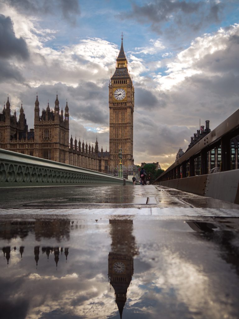 Big Ben and the Houses of Parliament seen from Westminster Bridge after rain with wet pavement reflections