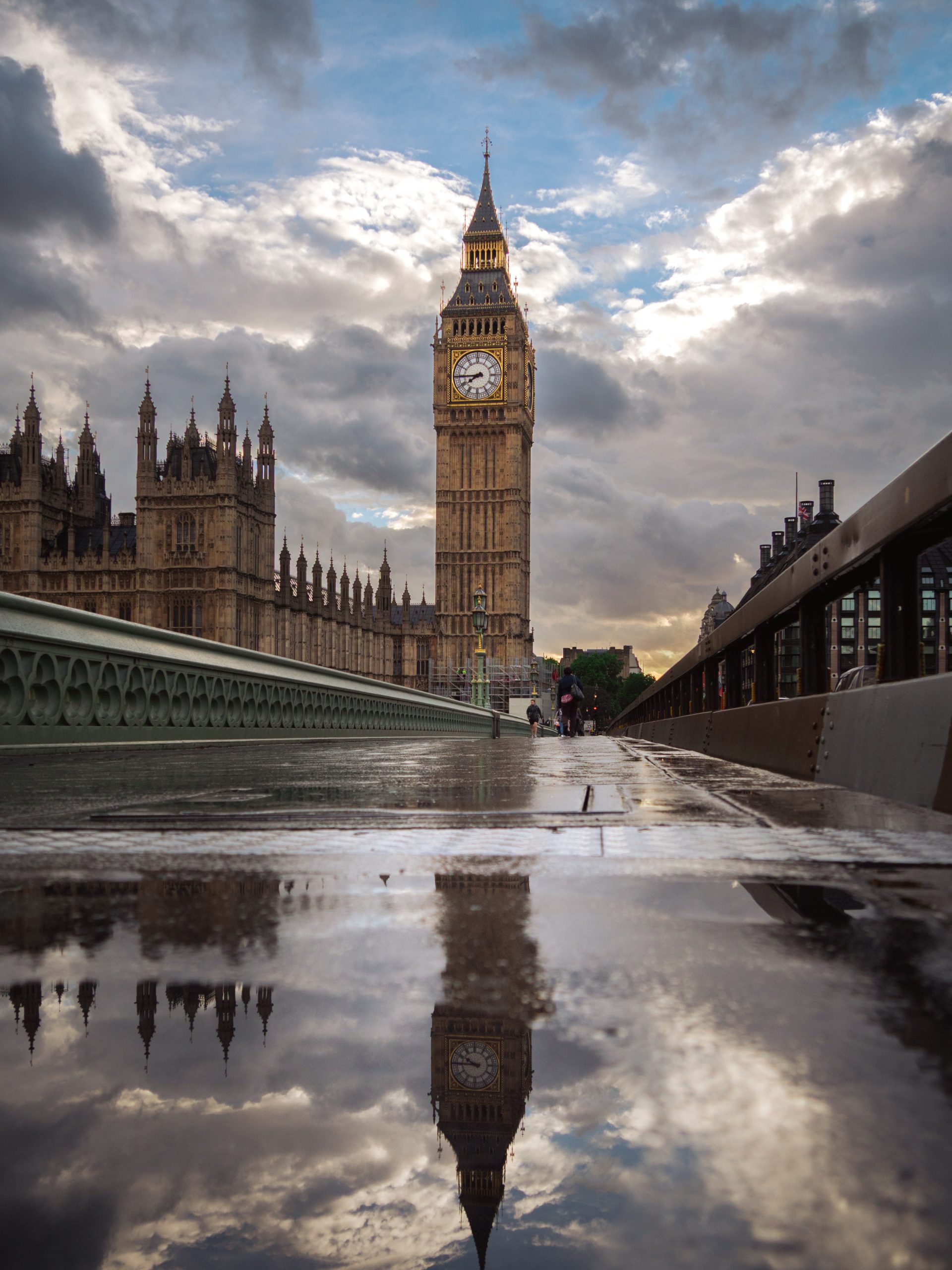 Big Ben and the Houses of Parliament seen from Westminster Bridge after rain with wet pavement reflections