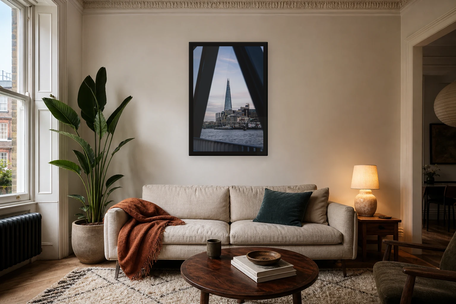 The Shard Between Shadows print shown edge to edge in a black frame above a sofa.
