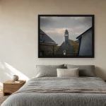 Room visualisation of Storm Over the Belfry in a black frame, shown at 80 x 60 cm