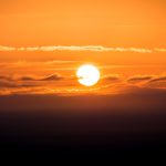 Orange sunset sky photography print with glowing sun, layered clouds and warm golden light