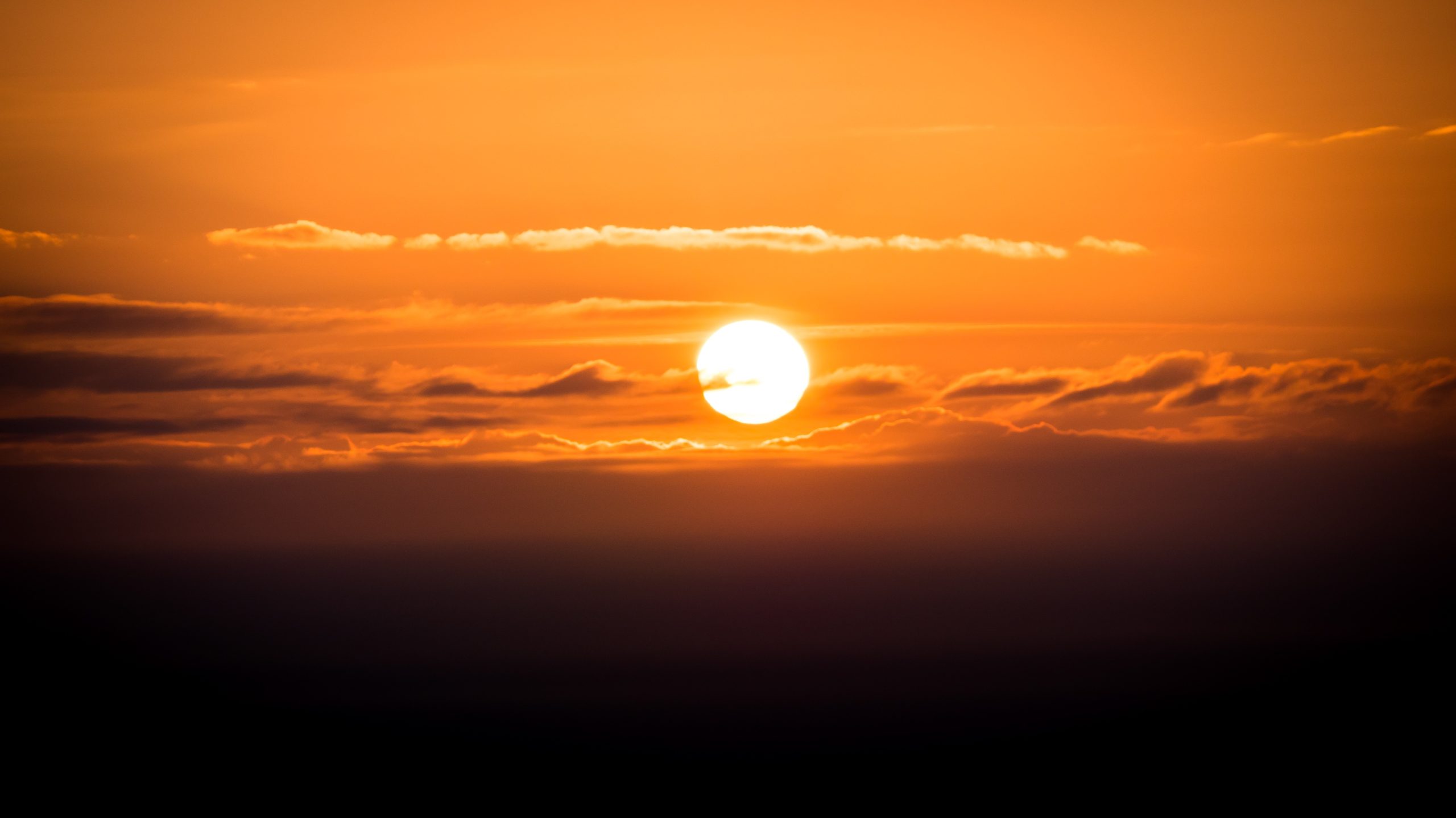 Orange sunset sky photography print with glowing sun, layered clouds and warm golden light
