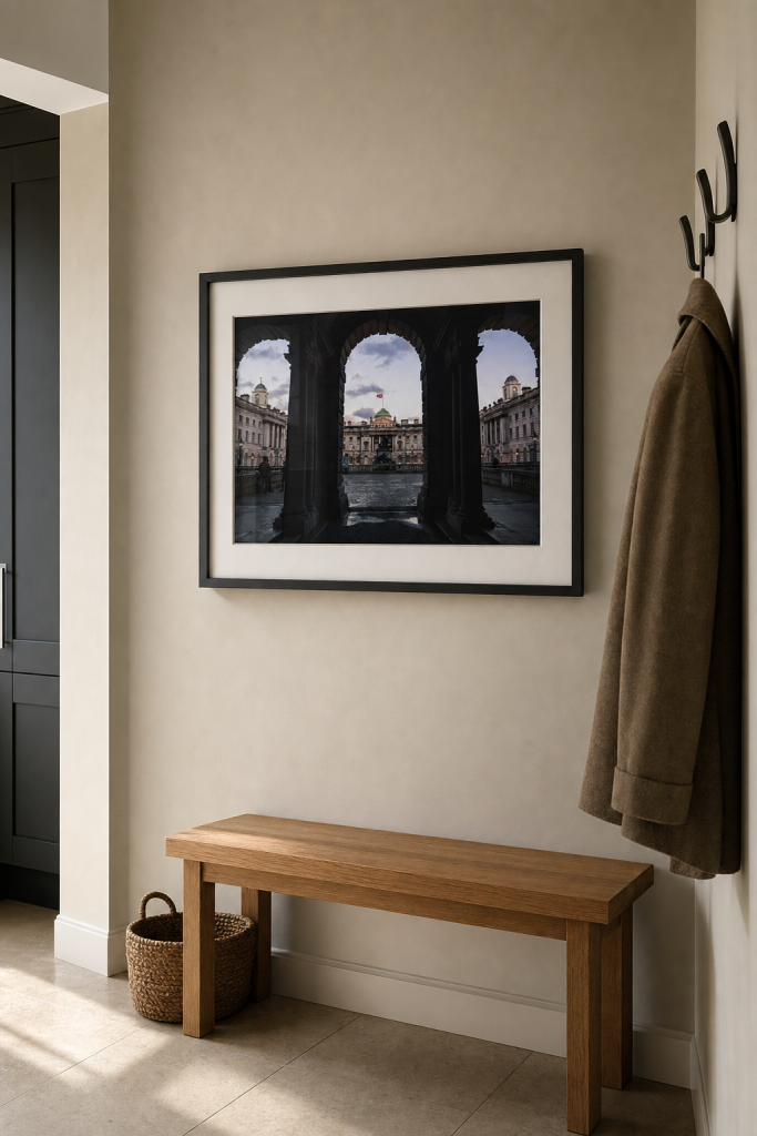 A framed London architecture photography print above a bench in a calm modern entryway.