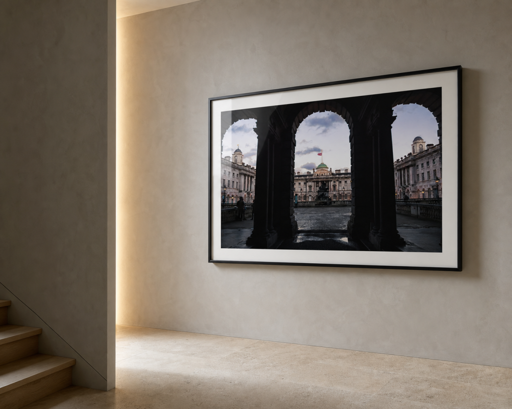 A framed London Arches at Dusk photography print on a minimal contemporary stair landing wall.